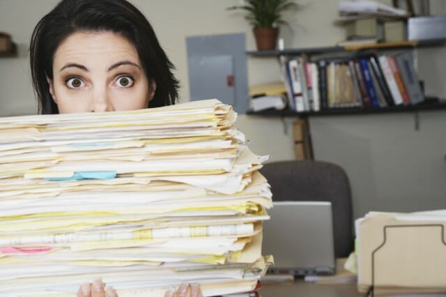 Surprised-woman-behind-stack-of-files_jpg