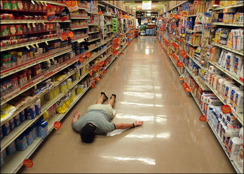 a man laying on the floor in a supermarket