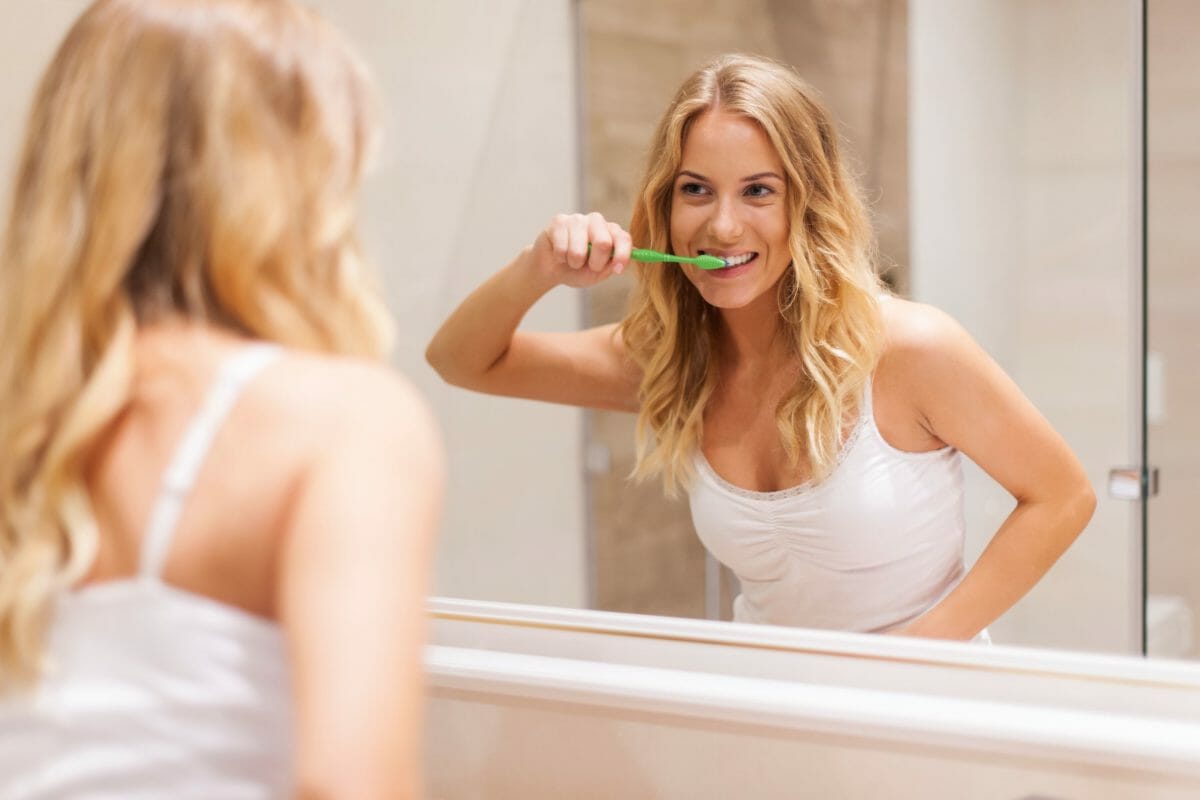 woman-brushing-teeth-front-mirror